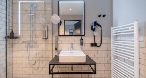 a bathroom with a sink and a shower at PLAZA INN Ulm in Ulm