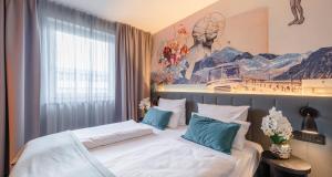 a bedroom with two beds and a painting on the wall at PLAZA INN Ulm in Ulm