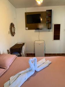 a room with a bed with a towel on it at Pousada da Lucinha in Canoa Quebrada