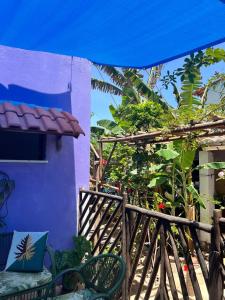 a purple house with a child sitting in a chair outside at Pousada da Lucinha in Canoa Quebrada