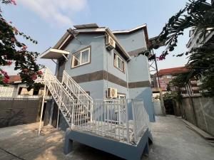 a blue house with a staircase in front of it at Freetown's most comfortable in Freetown