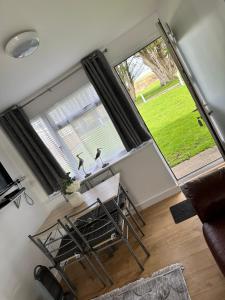 a living room with a table and a large window at Tranquility at Sandown Bay in Sandown
