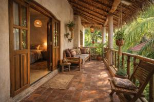 eine Veranda mit einer Couch und einem Bett in der Unterkunft Hotel Comentom Vrindavan in Vrindāvan
