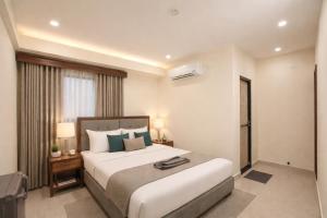 ein Schlafzimmer mit einem großen weißen Bett und einem Fenster in der Unterkunft Hotel Comentom Vrindavan in Vrindāvan