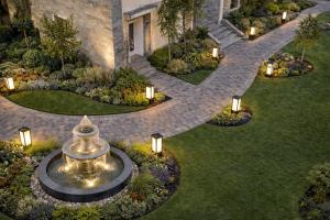 Draufsicht auf einen Garten mit Springbrunnen und Beleuchtung in der Unterkunft Hotel Comentom Vrindavan in Vrindāvan + 1 Foto