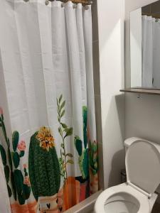 a bathroom with a toilet with a cactus shower curtain at Apartamento en clima caliente in Apulo +9 photos