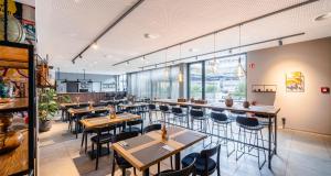 a restaurant with wooden tables and chairs and windows at PLAZA INN Ulm in Ulm +47 photos