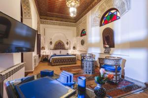 ein großes Wohnzimmer mit einem Bett und einem Tisch in der Unterkunft Riad Fes Maya suite & spa in Fès