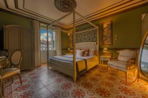 a bedroom with a canopy bed and a chair at Solar dos Poetas in Lisbon