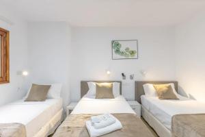 two beds in a room with white walls at TeXeda Room Suites in Tejeda