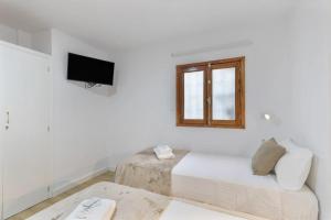 a white room with a bed and a window at TeXeda Room Suites in Tejeda