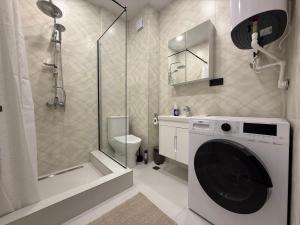 ein Badezimmer mit Waschmaschine und Dusche in der Unterkunft SofiCoast in Gonio + 20 Fotos