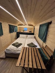 a bedroom with a bed and a table in it at Glamping Vejtřaska in Mochtín
