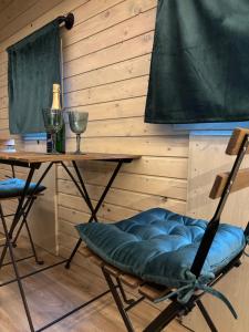 a room with a table and a chair and wine glasses at Glamping Vejtřaska in Mochtín +25 photos