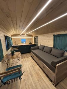 a living room with a couch and a table at Glamping Vejtřaska in Mochtín