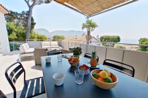 a table with a bowl of fruit on a balcony at Home Cassis - Maison Méditerranée - Piscine chauffée à 30c in Cassis