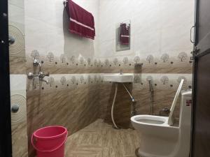 a bathroom with a toilet and a sink at Hotel Dausa Place in Dausa