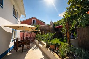 a patio with a table and an umbrella at CasaRica Retreat in Charneca