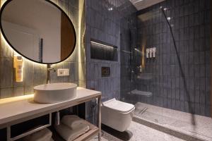 a bathroom with a sink and a toilet and a mirror at IGMAR Villas & Aparts Hotel in Tashkent +36 photos