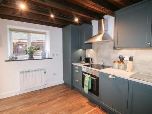 a kitchen with blue cabinets and a sink at The Loft in Kilkenny +16 photos