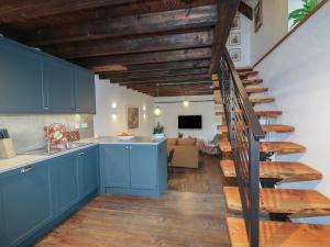 a kitchen with blue cabinets and a spiral staircase at The Loft in Kilkenny