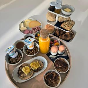 a table with a tray of breakfast foods on it at B&B De Stuifduinen in Wetteren +25 photos