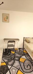 a table with a chair on a carpet in a room at Havre De Paix Réside in Le Mée-sur-Seine