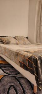 a bed with a comforter on it in a room at Havre De Paix Réside in Le Mée-sur-Seine