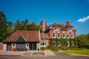 an old red brick house with a parking lot at The Grange in Upper Arley