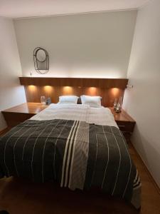 ein Schlafzimmer mit einem großen Bett mit hölzernem Kopfteil in der Unterkunft Hotel Glymur in Leirá + 98 Fotos