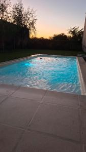 a swimming pool with blue water in a yard at Chacra Arcoiris in Gualeguay +9 photos