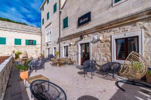 a group of chairs and tables outside of a building at Rooms Bed and Breakfast Blanc in Pučišća