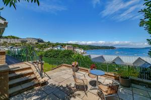 a patio with a table and chairs and the ocean at Finest Retreats - Bownder House in Cawsand