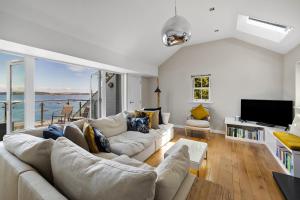 a living room with a white couch and a tv at Finest Retreats - Bownder House in Cawsand