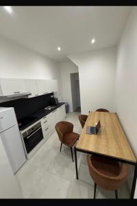 a kitchen with a wooden table and chairs in it at Grande rue in Roubaix