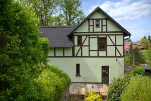 a green and white house with a black roof at Penzion Arosa in Růžová