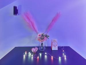 a table with a vase of flowers and lights at Romantic Studio Marki LoveAparts in Marki