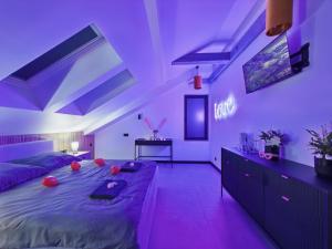 a bedroom with a large bed with purple lighting at Romantic Studio Marki LoveAparts in Marki