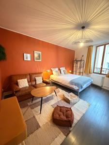 a living room with a bed and a couch at L'instant Nevers in Charleville-Mézières