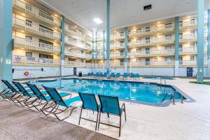 a pool in a hotel with chairs in front of a building at Resort Retreat - Multiple Pools - Beach Access in Hilton Head Island