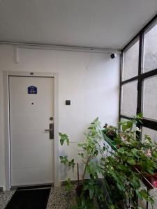 a white door in a room with plants at Studio Apartment-Horizont 47 in Novi Sad