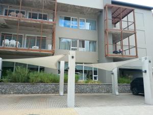 a building with a white umbrella in front of it at Departamento BOSQUE - Unidad 218 in Costa del Este
