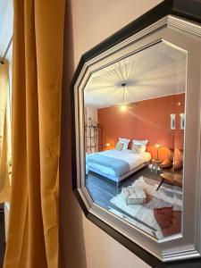 a bedroom with a bed and a mirror at L'instant Nevers in Charleville-Mézières