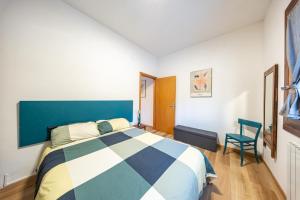 a bedroom with a blue and white bed and a chair at Eco Home - Val di Luce in Abetone +59 photos