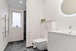 a white bathroom with a toilet and a sink at 20514-Samso-Plantagevej-17 in Sælvig +20 photos