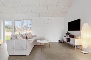 a white living room with a couch and a table at 20514-Samso-Plantagevej-17 in Sælvig