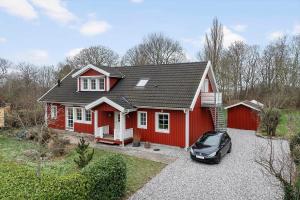 a red house with a car parked in front of it at 20427-Samso-Torup-13 in Torup