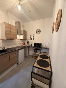 a large kitchen with wooden cabinets and a table at L'instant Nevers in Charleville-Mézières