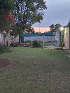 a yard with a fence and a building at taoana guesthouse in Kroonstad