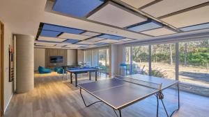 a living room with two ping pong tables and windows at Departamento BOSQUE - Unidad 218 in Costa del Este